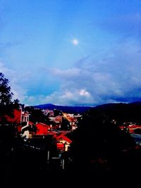 Buildings in town against cloudy sky