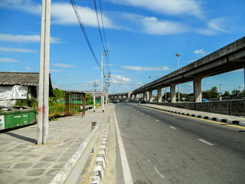 Road by bridge against sky in city