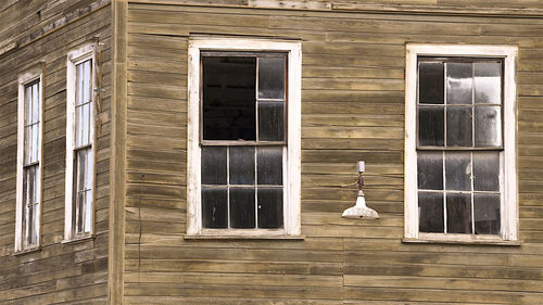 Two old windows in an old wood building