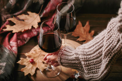 Midsection of woman holding wineglass on table