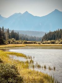 Scenic view of lake by mountains against sky