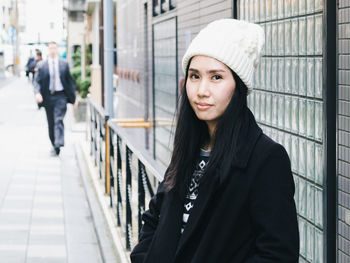 Young woman standing by railing