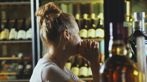 Young woman with hands clasped at bar counter