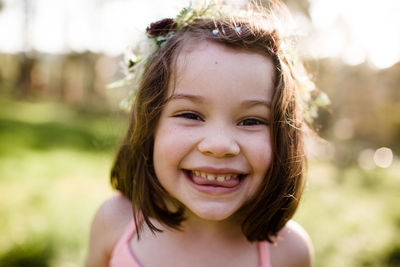 Close up of young girl in flower crown being silly