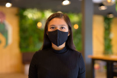 Portrait of woman covering face standing outdoors