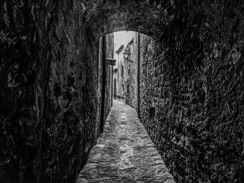 Footpath amidst buildings in the wall