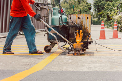 Road worker paint traffic lines on asphalt road surface