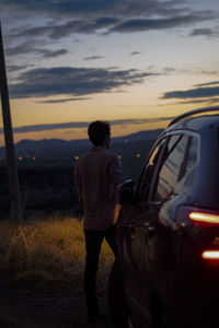 Rear view of man looking at sunset
