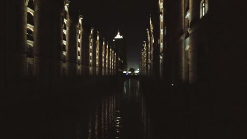 Man in illuminated building against sky at night