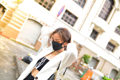 Side view of woman standing against building