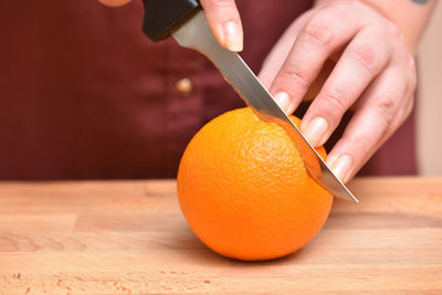 Close-up of hand holding orange