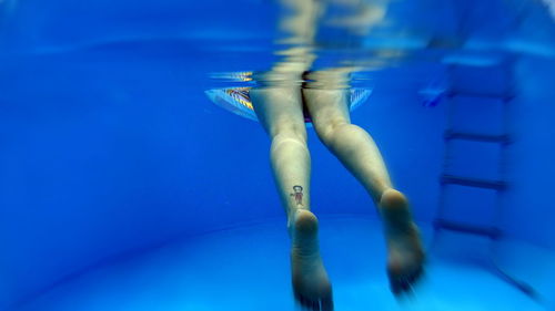 Low section of woman swimming in pool