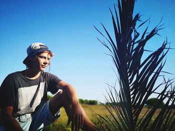 Low angle view of smiling woman against blue sky