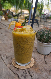 Close-up of healthy smoothie with passion fruit and pineapple placed on  wooden table.