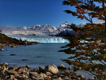 Scenic view of snowcapped mountains against blue sky