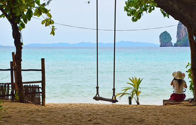 Rear view of a woman sitting on beach