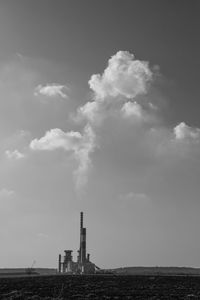 Smoke emitting from chimney against sky