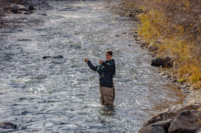 Teenage boy fishing in river