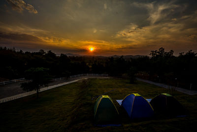 Scenic view of farm against sky during sunset