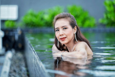 Portrait of smiling young woman in lake