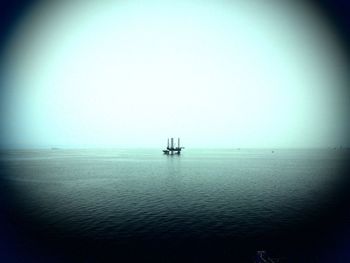 Sailboat in sea against clear sky