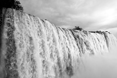 Low angle view of waterfall against sky
