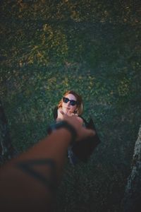 High angle view of woman reaching hand of person