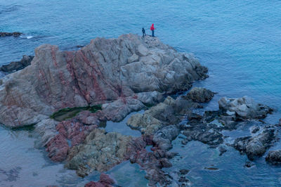 Man standing on rock by sea