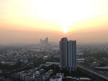 High angle view of modern buildings in city against sky during sunset