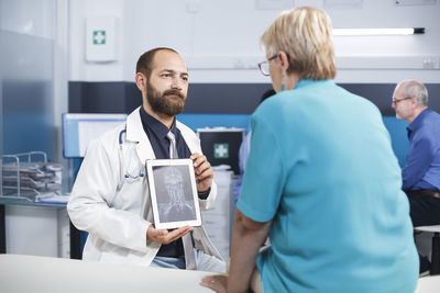 Portrait of doctor using mobile phone in office