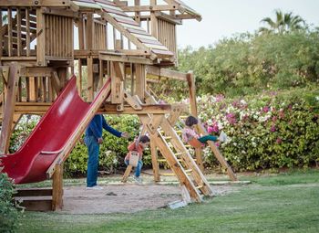 Father with kids enjoying swing at playground