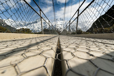 Surface level of chainlink fence against sky