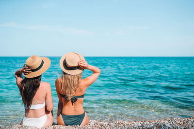 Rear view of hat on beach against sky