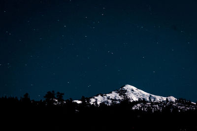 Scenic view of silhouette mountains against sky at night