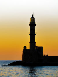 Silhouette of lighthouse against sky during sunset