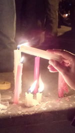 Midsection of person holding illuminated candles
