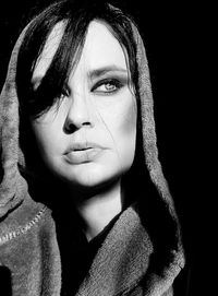 Close-up portrait of young woman over black background