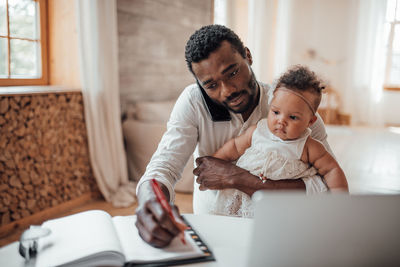 Father and son using smart phone at home