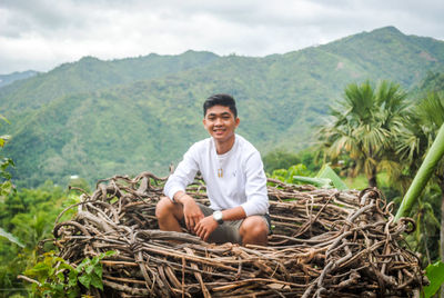 Portrait of smiling young man sitting on mountain nest