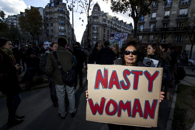 People on street against buildings in city