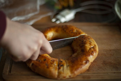 Close-up of hand holding bread on table