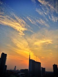 Low angle view of modern buildings against sky at sunset