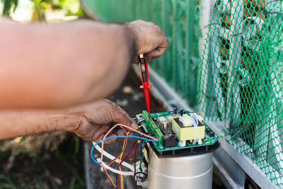 Electricians hand testing switches in electric mainboard.