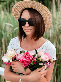 Portrait of woman wearing sunglasses holding flower