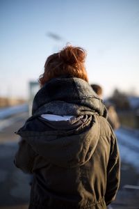 Rear view of woman standing on snow against sky