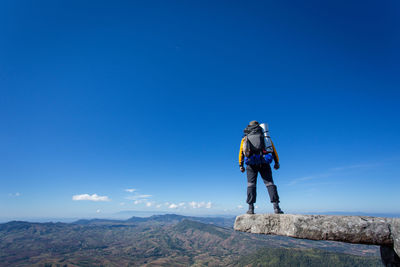 Man on mountain against blue sky