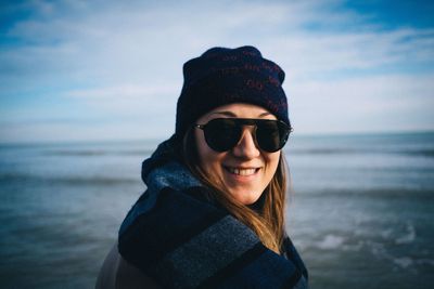 Portrait of man wearing sunglasses at beach against sky