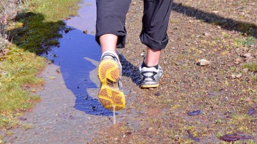 Low section of man walking on footpath