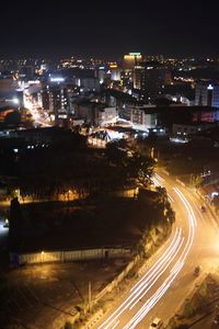 High angle view of illuminated street amidst buildings at night