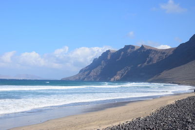 Scenic view of sea and mountains against sky